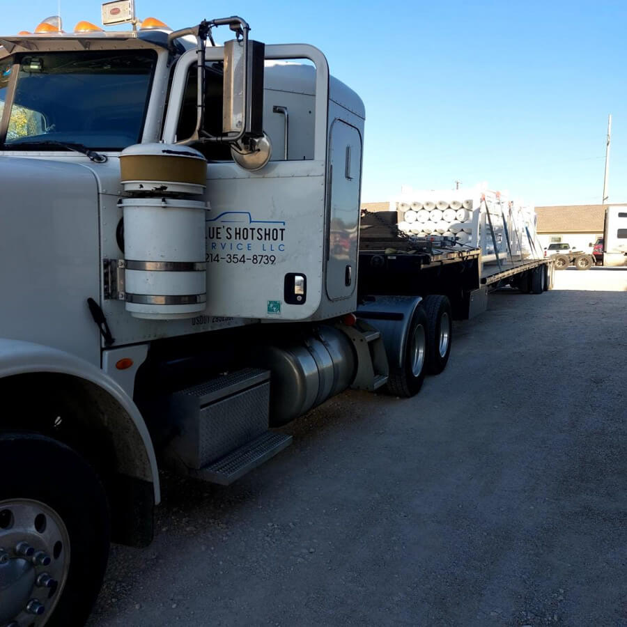 Blue's Hotshot Service dually and semi hauling tanks on flatbed trailers.